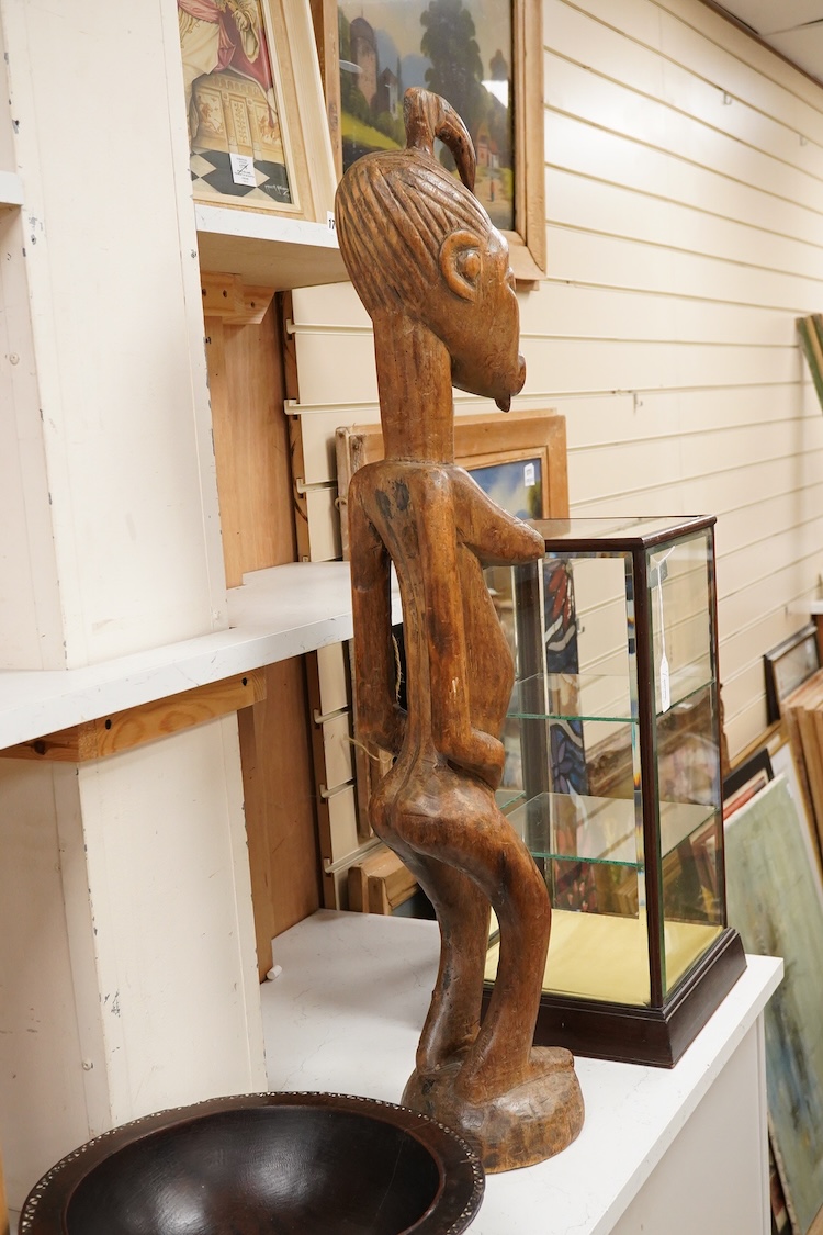 A Fijian carved wood Kava bowl and a West African Dogon fertility figure, 91cm tall